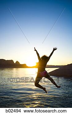 Stock Photo - rear view of a 
young woman jumping 
into a lake. fotosearch 
- search stock 
photos, pictures, 
images, and photo 
clipart