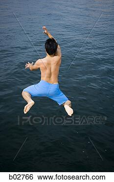 Stock Photo - rear view of a 
young man jumping 
in a lake. fotosearch 
- search stock 
photos, pictures, 
images, and photo 
clipart