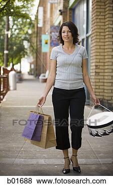 Stock Photo - mid adult woman 
walking with shopping 
bags. fotosearch 
- search stock 
photos, pictures, 
images, and photo 
clipart