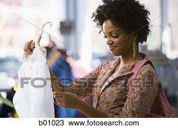 Stock Photo - profile of a young 
woman reading 
a price tag on 
a shirt. fotosearch 
- search stock 
photos, pictures, 
images, and photo 
clipart