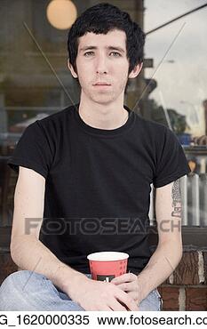 Stock Image - a skinny young 
man sits in front 
of a shop while 
enjoying a drink. 
fotosearch - search 
stock photos, 
pictures, images, 
and photo clipart