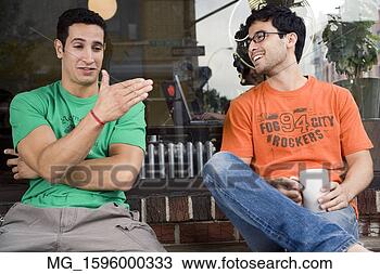 Stock Photo - two young men 
hang talk infront 
of a shop while 
enjoying a drink. 
fotosearch - search 
stock photos, 
pictures, images, 
and photo clipart