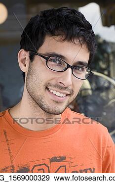 Stock Photograph - a young man in 
glasses and an 
 orange shirt 
outside a shop 
september. fotosearch 
- search stock 
photos, pictures, 
images, and photo 
clipart