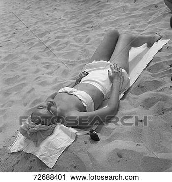 Stock Photography - woman sun tanning 
on beach, (b&w), 
elevated view. 
fotosearch - search 
stock photos, 
pictures, images, 
and photo clipart