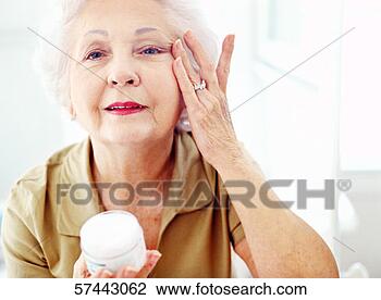 Stock Photo - portrait of an 
elderly woman 
applying wrinkle 
cream. fotosearch 
- search stock 
photos, pictures, 
images, and photo 
clipart