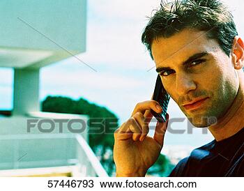 Stock Photo - close-up of a 
man on a balcony 
talking on a mobile 
phone. fotosearch 
- search stock 
photos, pictures, 
images, and photo 
clipart