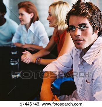 Stock Photo - close-up of a 
man sitting at 
a table in a meeting 
with co-workers. 
fotosearch - search 
stock photos, 
pictures, images, 
and photo clipart