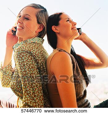 Stock Photography - close-up of two 
women sitting 
back to back talking 
on mobile phones. 
fotosearch - search 
stock photos, 
pictures, images, 
and photo clipart