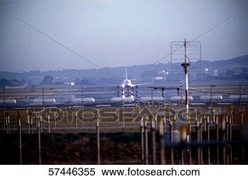 Stock Image - distant view of 
an aircraft waiting 
at the runway 
for take-off. 
fotosearch - search 
stock photos, 
pictures, images, 
and photo clipart