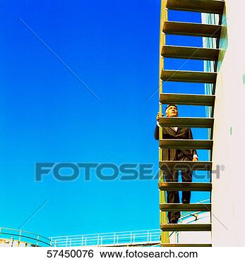 Stock Photo - low angle view 
from under a ladder 
of a man climbing 
on it. fotosearch 
- search stock 
photos, pictures, 
images, and photo 
clipart