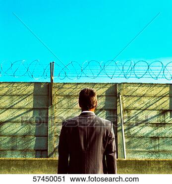Stock Photography - view from behind 
of a businessman 
standing in a 
barbed enclosure. 
fotosearch - search 
stock photos, 
pictures, images, 
and photo clipart