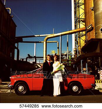 Stock Image - portrait of newly 
weds standing 
beside a parked 
car at an industrial. 
fotosearch - search 
stock photos, 
pictures, images, 
and photo clipart