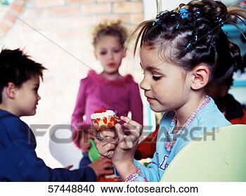 Stock Photography - a young girl (4-6) 
unwrapping candy 
with children 
in the background. 
fotosearch - search 
stock photos, 
pictures, images, 
and photo clipart
