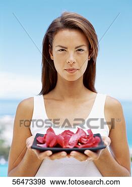 Stock Photo - portrait of a 
young woman holding 
a plate of flower 
petals. fotosearch 
- search stock 
photos, pictures, 
images, and photo 
clipart