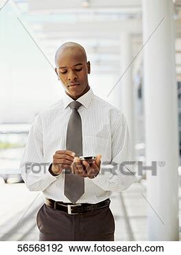 Stock Photo - businessman using 
a hand held device 
in an office. 
fotosearch - search 
stock photos, 
pictures, images, 
and photo clipart