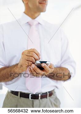 Stock Photo - mid section view 
of a businessman 
using a hand held 
device. fotosearch 
- search stock 
photos, pictures, 
images, and photo 
clipart