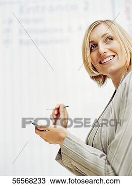 Stock Photo - side profile of 
a businesswoman 
holding a hand 
held device in 
an. fotosearch 
- search stock 
photos, pictures, 
images, and photo 
clipart