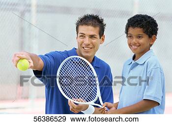 Stock Photograph - close-up of a 
young man teaching 
a boy how to play 
tennis. fotosearch 
- search stock 
photos, pictures, 
images, and photo 
clipart