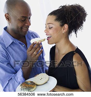 Stock Photo - young man feeding 
a bagel to a young 
woman. fotosearch 
- search stock 
photos, pictures, 
images, and photo 
clipart