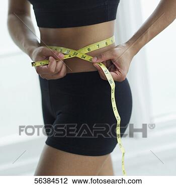Banco de Imagem - jovem,  mulher, 
 medindo,  dela, 
 cintura,  medindo, 
 fita. fotosearch 
- busca de fotos, 
imagens e clipart