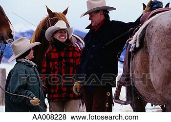 Stock Photo - family standing 
with horses in 
the snow. fotosearch 
- search stock 
photos, pictures, 
images, and photo 
clipart