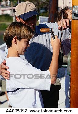 Stock Photo - boy turning a 
winch to raise 
a sailling boat 
sail. fotosearch 
- search stock 
photos, pictures, 
images, and photo 
clipart