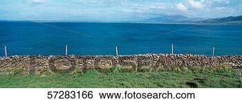 Stock Photo - fence on a stone 
wall with brandon 
point,  co kerry, 
 ireland in the. 
fotosearch - search 
stock photos, 
pictures, images, 
and photo clipart