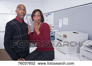 Stock Photo - office workers, 
 mature woman 
sitting on table, 
 young man touching. 
fotosearch - search 
stock photos, 
pictures, images, 
and photo clipart
