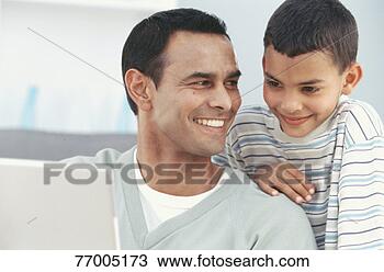 Stock Photo - father and son 
(6-7 years) using 
laptop indoors, 
close up. fotosearch 
- search stock 
photos, pictures, 
images, and photo 
clipart