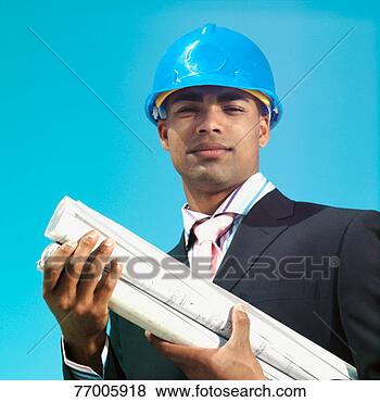Stock Photo - young businessman 
wearing hard hat 
and holding blueprints, 
portrait. fotosearch 
- search stock 
photos, pictures, 
images, and photo 
clipart