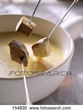 Stock Photography - cheese fondue 
with bread cubes 
on fondue forks. 
fotosearch - search 
stock photos, 
pictures, images, 
and photo clipart