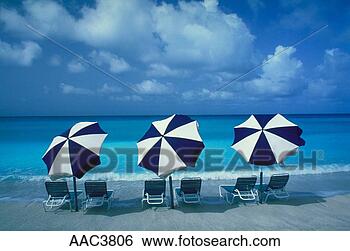 Stock Photo - three blue and 
white umbrellas 
and six lounge 
chairs sitting 
in the. fotosearch 
- search stock 
photos, pictures, 
images, and photo 
clipart