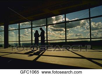 Stock Image - silhouette of 
two business people 
talking against 
large windows 
with. fotosearch 
- search stock 
photos, pictures, 
images, and photo 
clipart