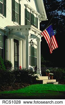Stock Photo - american flag 
hangs from the 
front porch of 
a traditional 
colonial. fotosearch 
- search stock 
photos, pictures, 
images, and photo 
clipart
