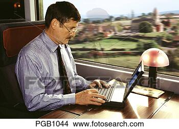 Stock Photo - businessman using 
laptop computer 
in first class 
carriage on. fotosearch 
- search stock 
photos, pictures, 
images, and photo 
clipart