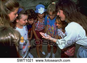 Stock Photography - teacher showing 
a butterfly to 
a group of fascinated 
young girls at. 
fotosearch - search 
stock photos, 
pictures, images, 
and photo clipart