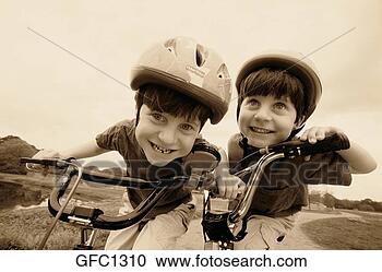 Stock Photography - close-up of twin 
boys who are wearing 
helmets while 
riding their. 
fotosearch - search 
stock photos, 
pictures, images, 
and photo clipart