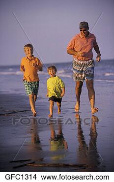 Stock Photo - father with his 
two boys jogging 
along the beach 
shore on a sunny 
day. fotosearch 
- search stock 
photos, pictures, 
images, and photo 
clipart