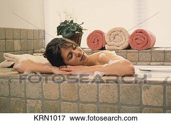 Picture - woman resting 
her head on the 
side of her bathtub 
while taking a. 
fotosearch - search 
stock photos, 
pictures, images, 
and photo clipart