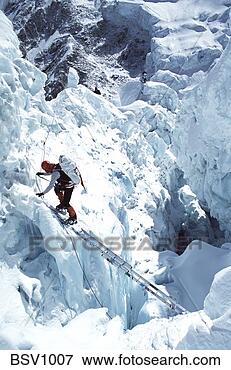 Picture - mountain climber 
uses a ladder 
to cross a gorge 
in the khumbu 
icefall. fotosearch 
- search stock 
photos, pictures, 
images, and photo 
clipart
