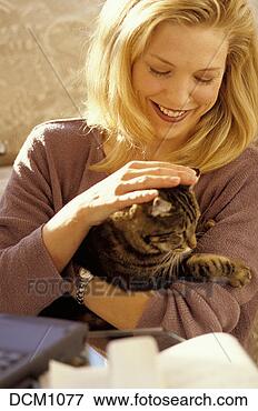 Picture - thirty year old 
woman sitting 
in her home-office 
holding her cat 
and. fotosearch 
- search stock 
photos, pictures, 
images, and photo 
clipart