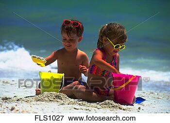 Picture - a young boy and 
girl sitting along 
the water’s edge 
playing in the. 
fotosearch - search 
stock photos, 
pictures, images, 
and photo clipart