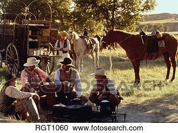 Stock Photography - group of wranglers 
sitting around 
fire pit with 
chuck wagon and 
cook. fotosearch 
- search stock 
photos, pictures, 
images, and photo 
clipart