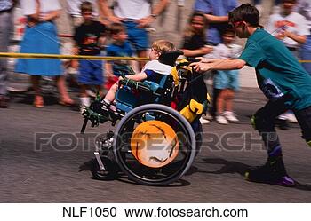 Stock Photography - handicapped child 
in wheelchair 
being pushed by 
brother on skates 
in. fotosearch 
- search stock 
photos, pictures, 
images, and photo 
clipart
