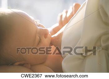 Picture - mother breast 
feeding baby in 
soft bedroom light. 
fotosearch - search 
stock photos, 
pictures, images, 
and photo clipart