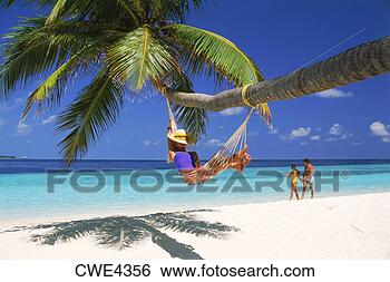 Stock Photo - couple passing 
woman in hammock 
on fihalhohi island 
in maldives. fotosearch 
- search stock 
photos, pictures, 
images, and photo 
clipart