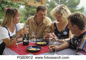 Stock Photo - four friends sitting 
outside on the 
terrace with a 
bottle of. fotosearch 
- search stock 
photos, pictures, 
images, and photo 
clipart