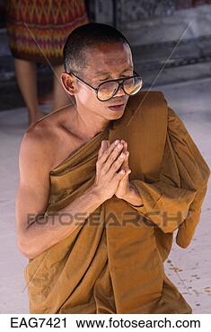 Stock Photography - a buddhist monk 
prostrates at 
wat phra keo which 
is part of the 
grand. fotosearch 
- search stock 
photos, pictures, 
images, and photo 
clipart