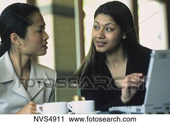 Stock Photography - an asian and latino 
woman having a 
business meeting 
drinking coffee. 
fotosearch - search 
stock photos, 
pictures, images, 
and photo clipart