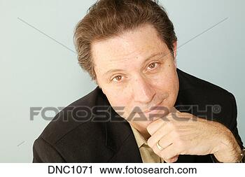 Stock Photography - studio shot of 
a brown-haired 
man with his chin 
on his hand and 
he. fotosearch 
- search stock 
photos, pictures, 
images, and photo 
clipart